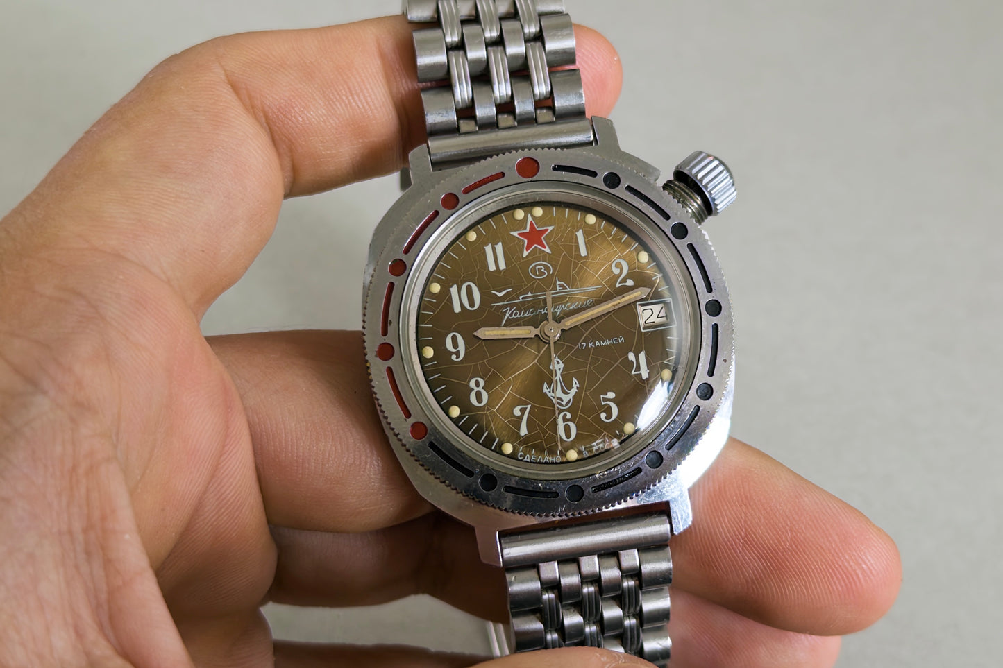 Vostok Komandirskie Tropical Spider held in hand, showing the crown and rotating bezel